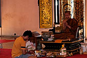 Chiang Mai - The Wat Chedi Luang, inside the viharn, young Buddhist monk gives their blessing. 